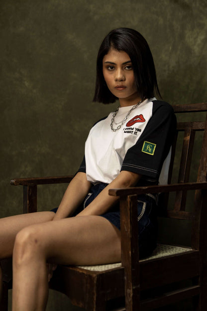 Tease Classic T-shirt (Unisex): model wearing the black-and-white T-shirt, seated front view