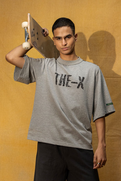 Soul Bound Lounge T-shirt (Unisex): model wearing the grey T-shirt holding a skateboard