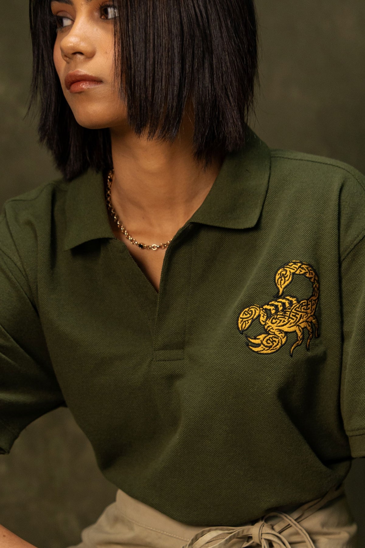 Death Sting Classic Polo (Unisex): model wearing the olive green polo, neckline and chest detail