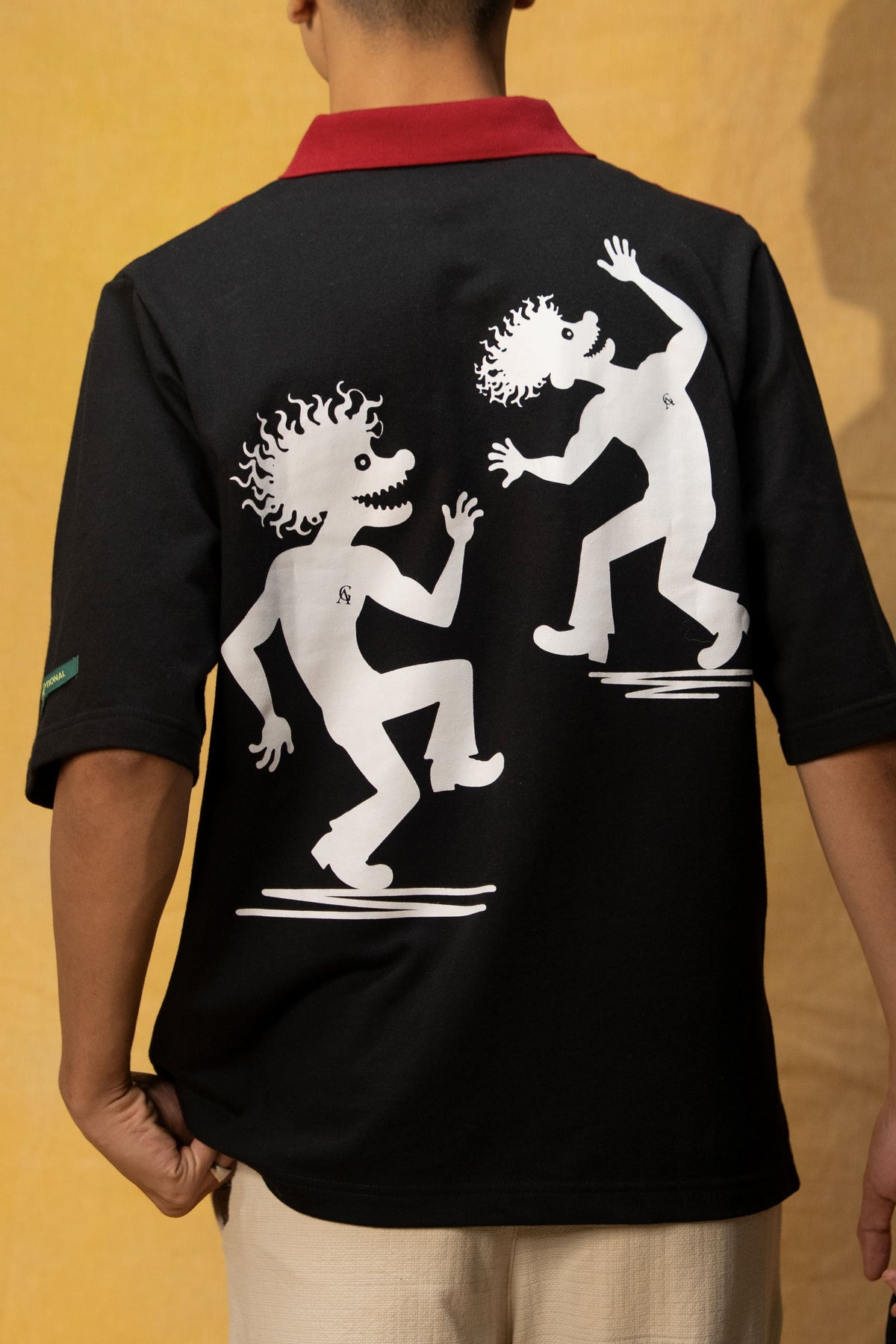 Drunk Freaks Lounge Polo (Unisex): back view on a model showing the white dancing figures