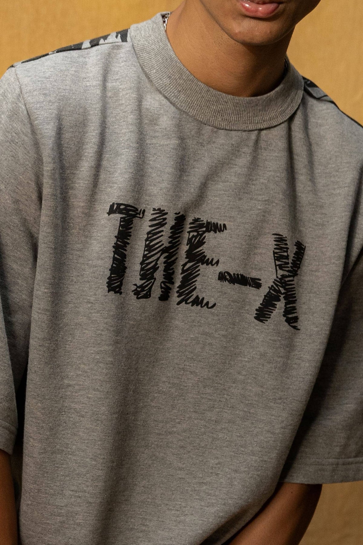 Soul Bound Lounge T-shirt (Unisex): close-up of the black THE-X chest lettering