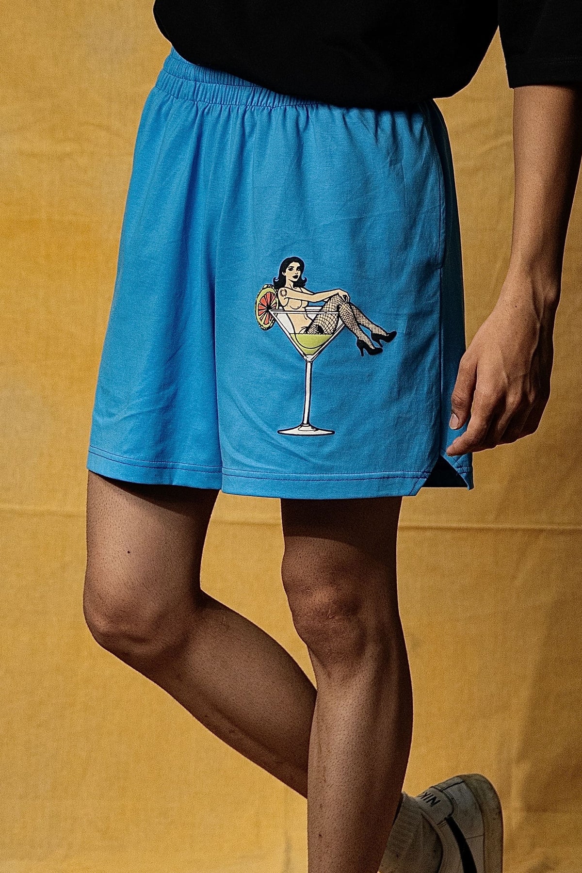 The Dirty Martini Lounge Shorts (Unisex): model wearing the blue shorts, angled front view