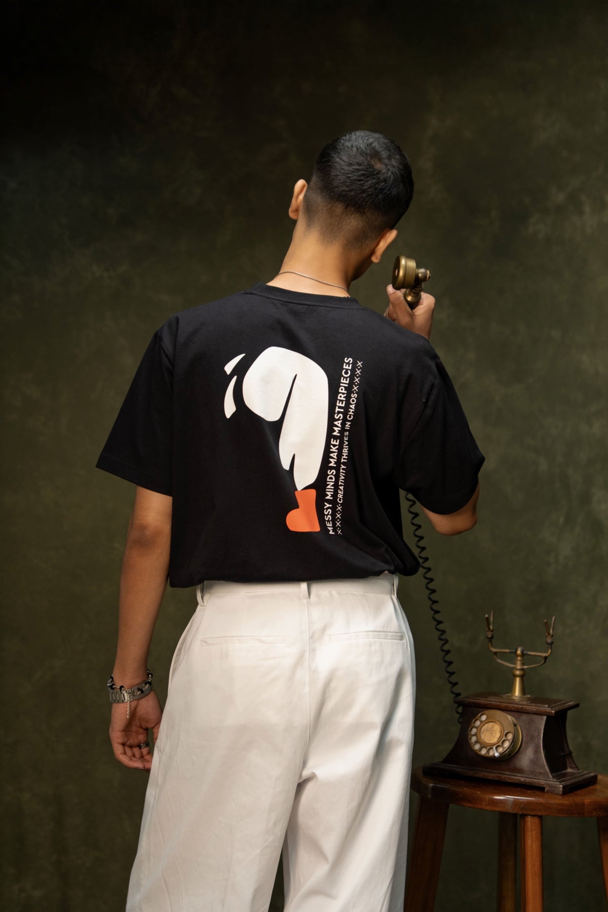 Messy Minds Classic T-shirt (Unisex): model wearing the black T-shirt, angled back view