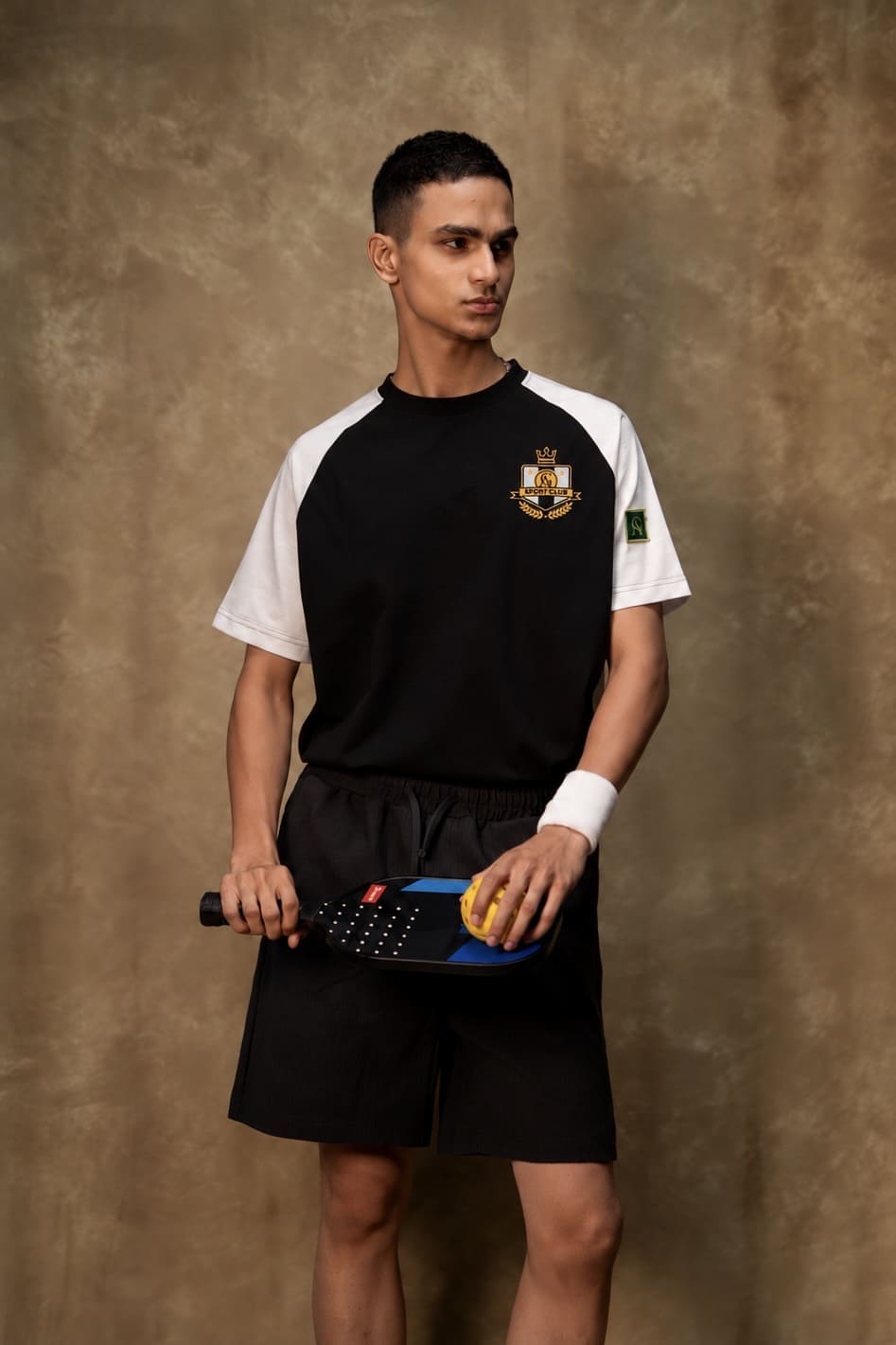 Pickled Classic T-shirt (Unisex): model wearing the T-shirt, front view with pickleball paddle