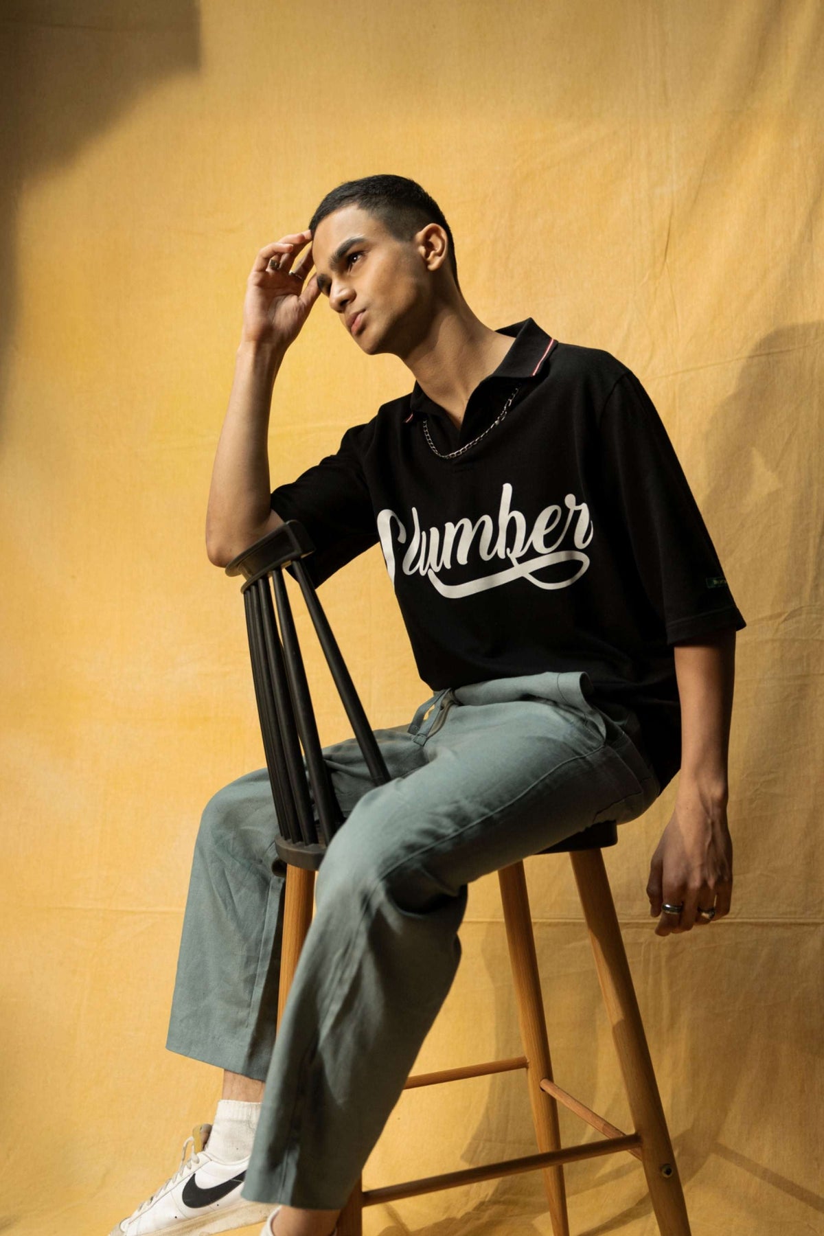 Slumber Lounge Polo (Unisex): model wearing the black polo, seated front view